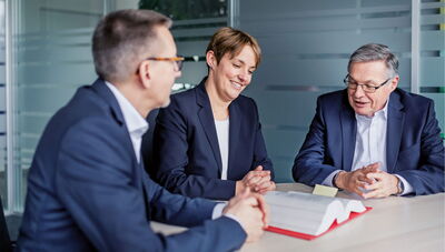 Kanzlei für Steuerberatung und Wirtschaftsprüfung Besprechung in der Gruppe mit drei Personen